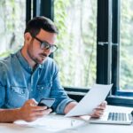 
                            man at desk reviewing ticket pricing strategy for his conference                            