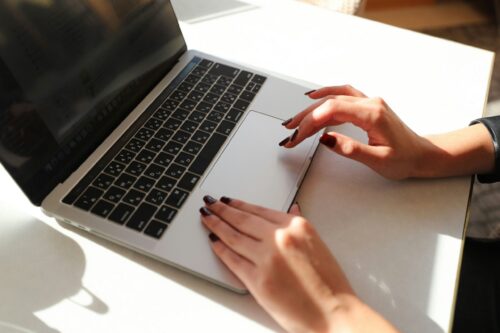 A woman typing on a laptop.